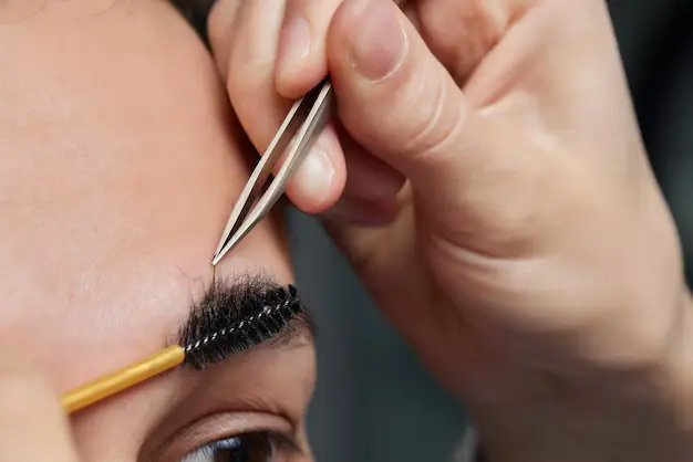professional-barber-doing-threading-procedure-correcting-shape-eyebrows-young-male-client-with-tweezer-barber-shop-barber-work-brow-care-concept-plucking-brows_